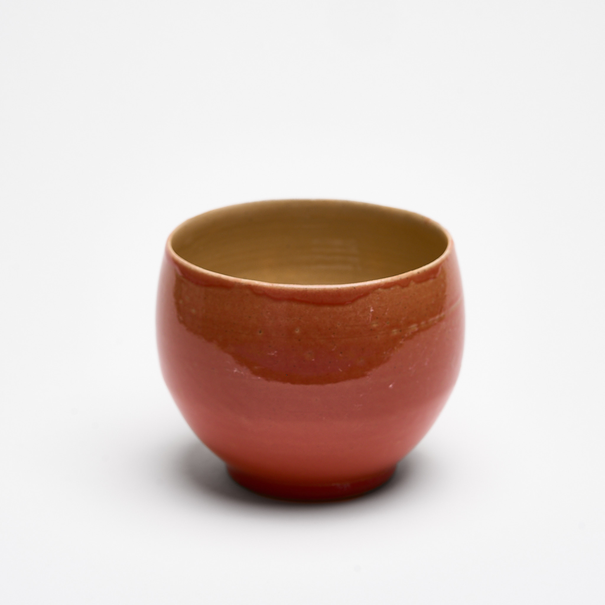 Handgemachte runde Steinzeugtasse in Koralle, innen naturfarben glasiert.