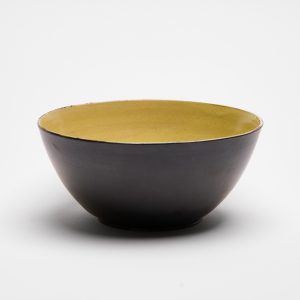 Handgemachte Steinzeug-Müslischüssel mit dunkler Aussenseite und gelb glasiertem Innenbereich.