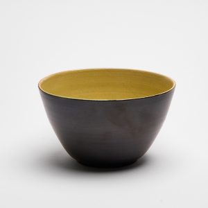 Handgefertigte Keramikschale aus Steinzeug mit schwarzer Außenseite und gelber Innenglasur, hergestellt in Basel